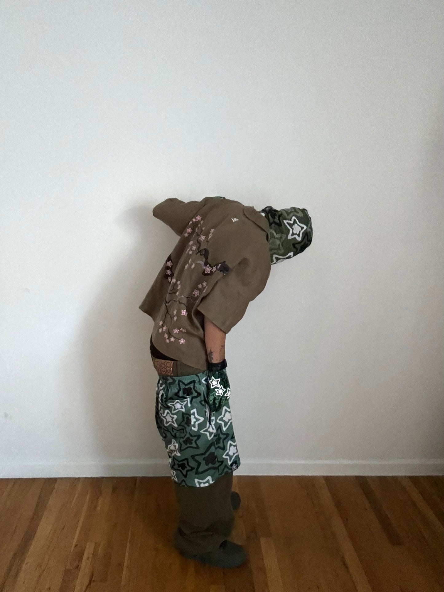 Person wearing a tan hoodie with floral patterns